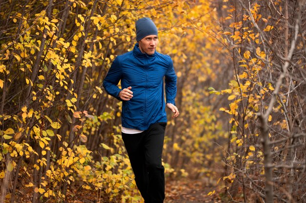 Uomo che corre sul sentiero nella foresta