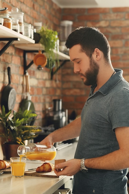 Uomo che cucina in cucina. Mattina colazione