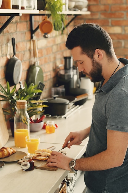 Uomo che cucina in cucina. Mattina colazione