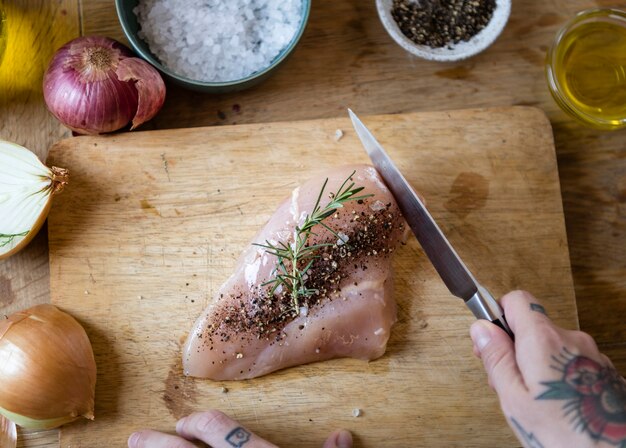 Uomo che cucina petto di pollo in cucina