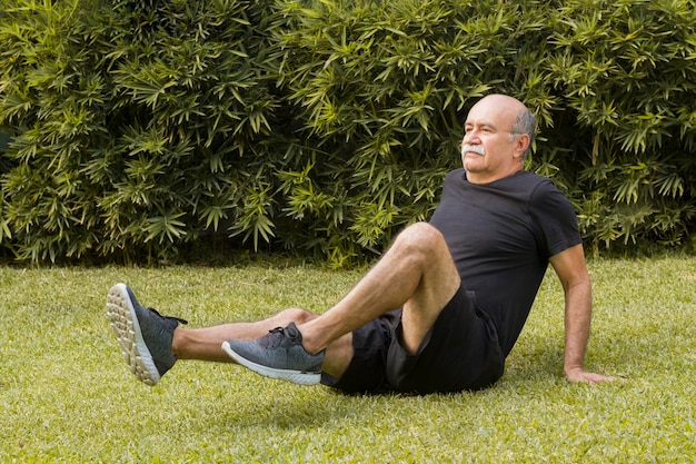 Uomo che fa gli esercizi di forma fisica nel parco