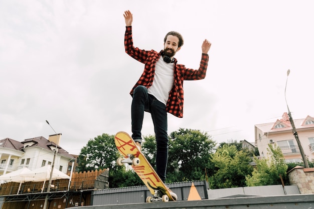 Uomo che fa i trucchi allo skate park