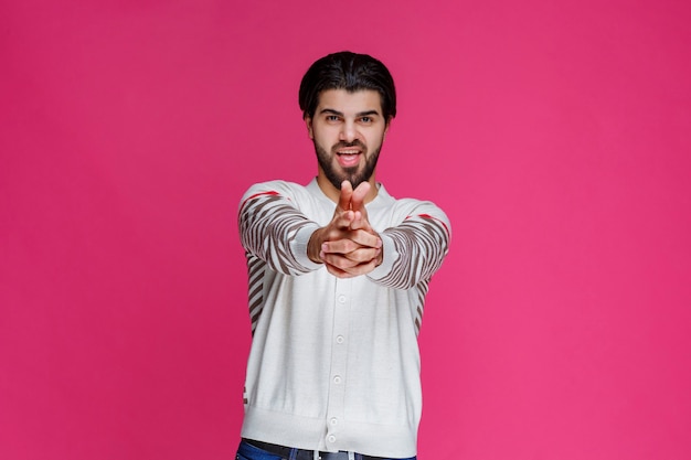 Uomo che fa il simbolo della pistola nella mano.