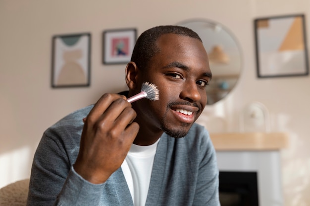 Uomo che fa il trucco al chiuso