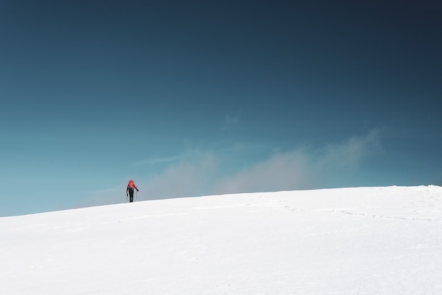 Uomo che fa un'escursione sulle montagne coperte di neve