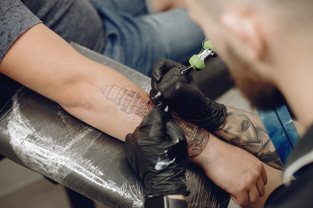 Uomo che fa un tatuaggio in un salone di tatuaggi