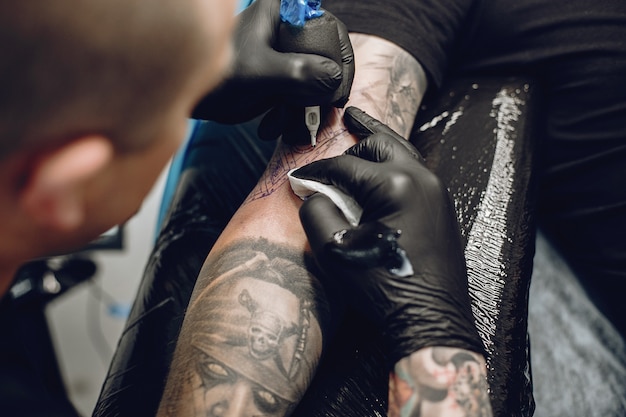 Uomo che fa un tatuaggio in un salone di tatuaggi