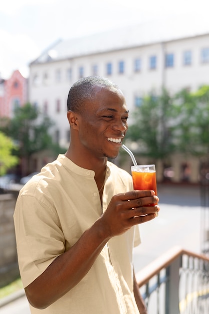 Uomo che fa una pausa caffè ghiacciata all'aperto