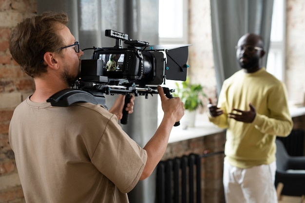 Uomo che filma con una telecamera professionale per un nuovo film