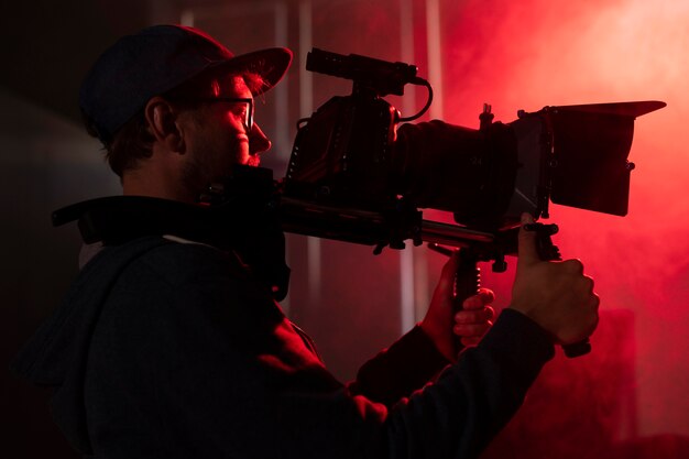 Uomo che filma con una telecamera professionale
