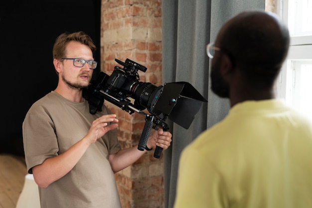 Uomo che filma con una telecamera professionale