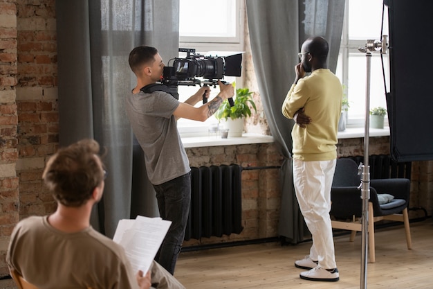 Uomo che filma con una telecamera professionale