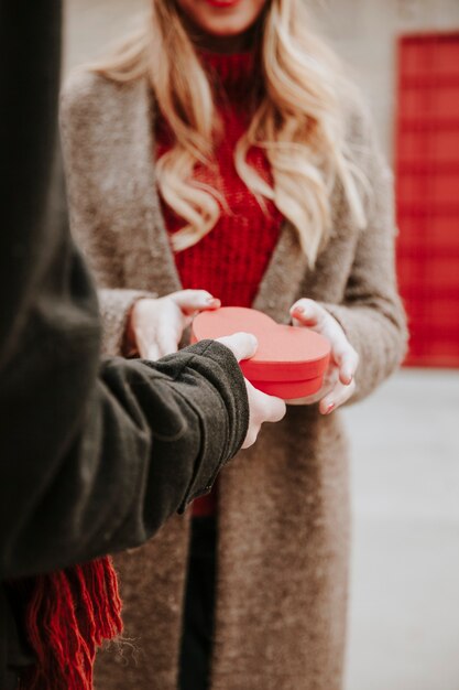 Uomo che gifting scatola a forma di cuore alla fidanzata