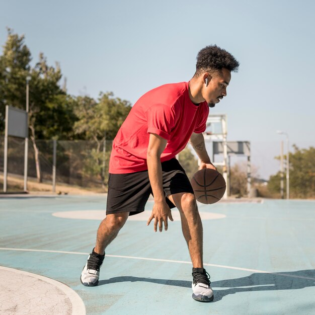 Uomo che gioca a basket all'esterno