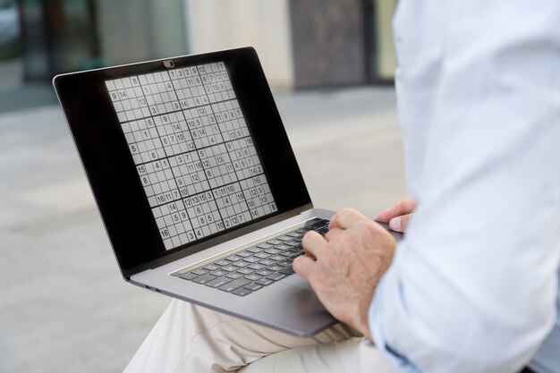 Uomo che gioca a sudoku sul suo laptop