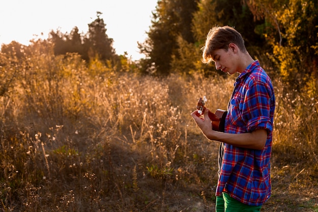 Uomo che gioca il colpo medio delle ukulele