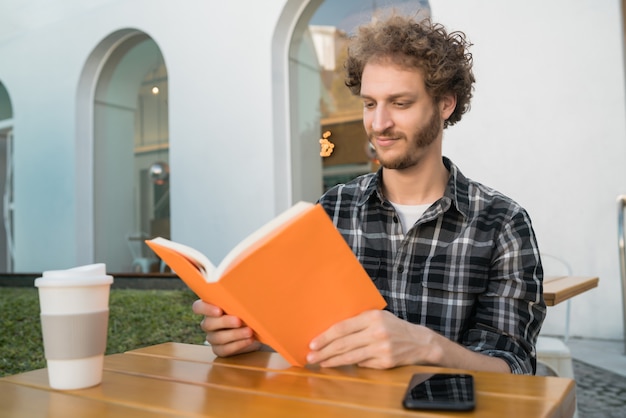 Uomo che gode del tempo libero e che legge un libro.