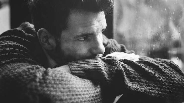 Foto gratuito uomo che guarda fuori dalla finestra