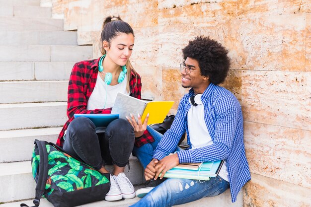 Uomo che guarda la sua amica che mostra qualcosa sul libro