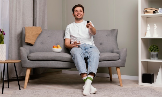 Uomo che guarda la tv e mangia popcorn