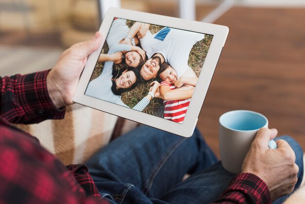 Uomo che guarda le foto con i suoi figli e nipoti