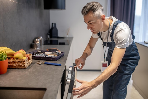 Uomo che guarda le informazioni sul pannello di controllo della lavastoviglie