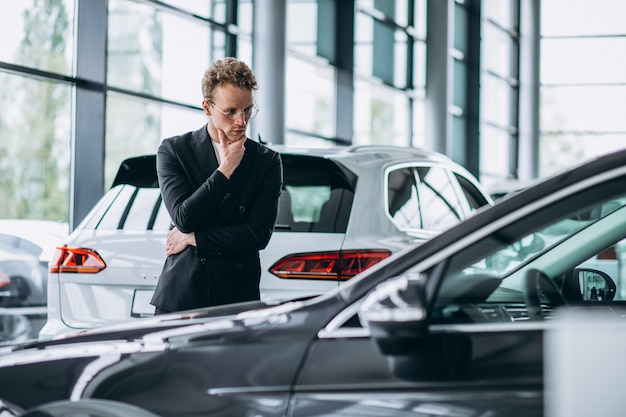 Uomo che guarda un&#39;auto e pensa a un acquisto