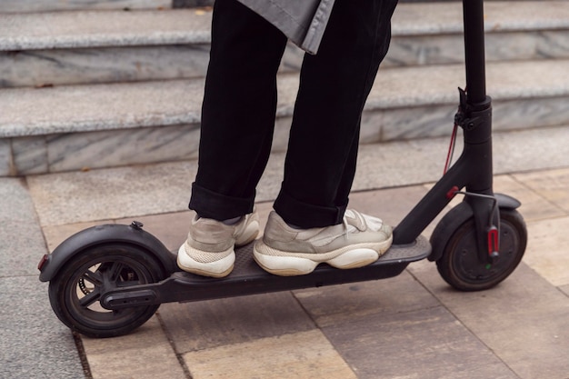 Uomo che guida il suo scooter elettrico all'aperto