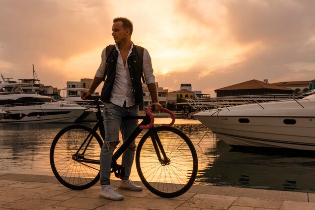 Uomo che guida la sua bici al tramonto