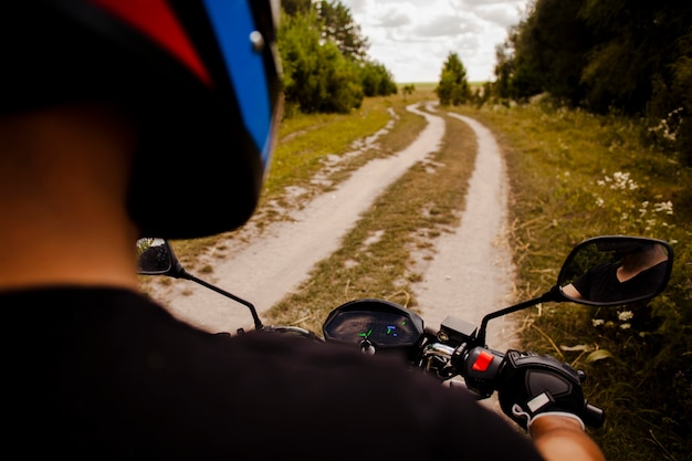 Uomo che guida una moto su strada sterrata