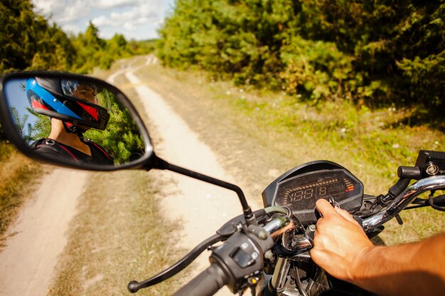 Uomo che guida una moto su strada sterrata