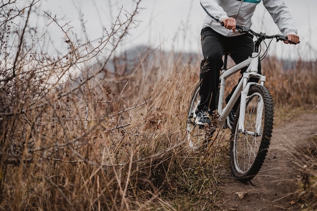 Uomo che guida una mountain bike in attrezzature speciali con copia spazio