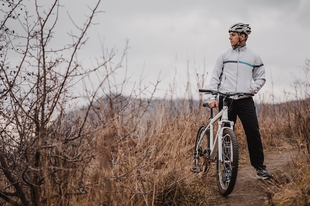 Uomo che guida una mountain bike in attrezzature speciali con copia spazio