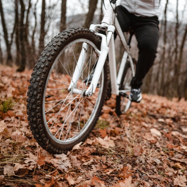 Uomo che guida una mountain bike su foglie d'autunno