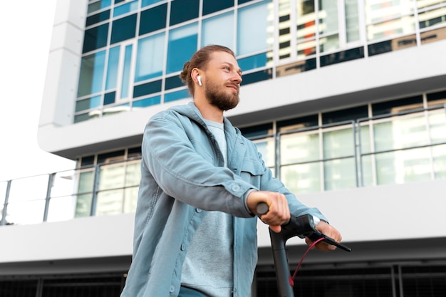 Uomo che guida uno scooter ecologico all'esterno