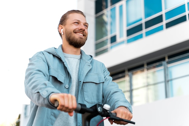 Uomo che guida uno scooter ecologico all'esterno