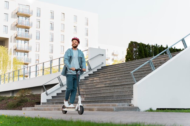 Uomo che guida uno scooter ecologico in città