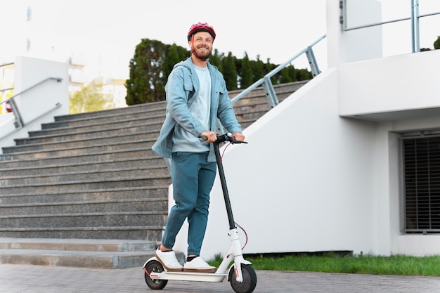 Uomo che guida uno scooter ecologico in città