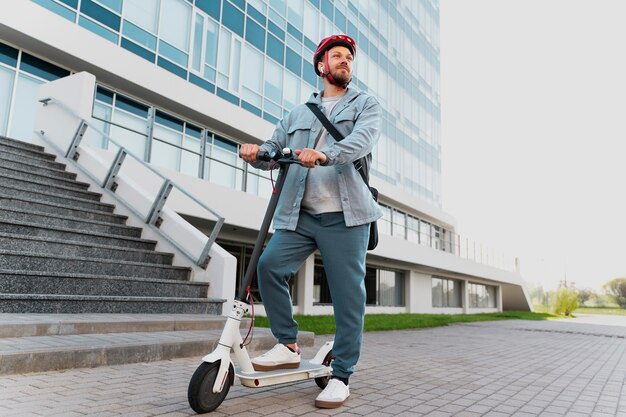 Uomo che guida uno scooter ecologico in città