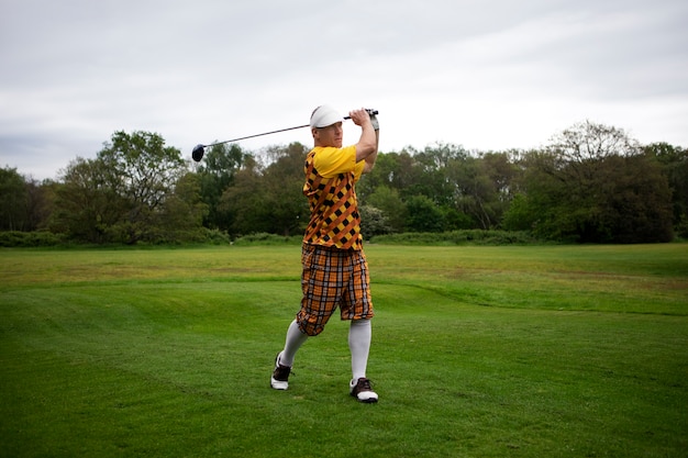 Uomo che ha una partita di golf all'aperto sul campo