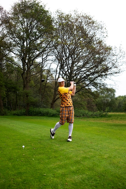 Uomo che ha una partita di golf all'aperto