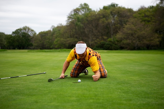 Uomo che ha una partita di golf all'aperto