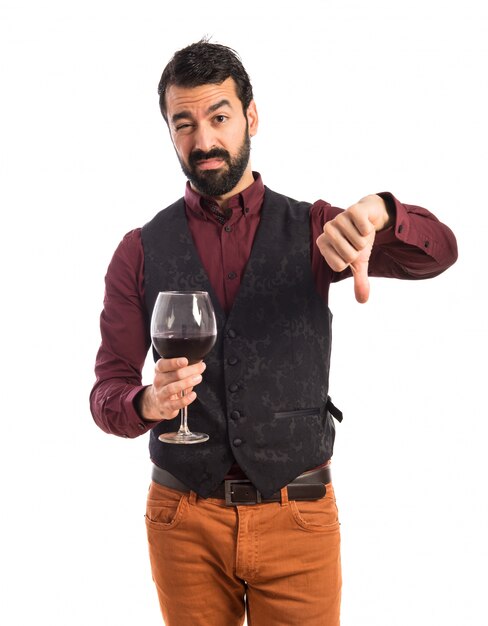 Uomo che indossa il panciotto che tiene un bicchiere di vino