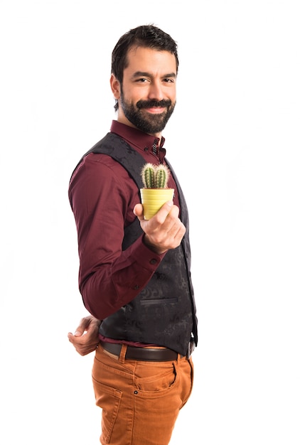 Uomo che indossa il panciotto in possesso di un cactus