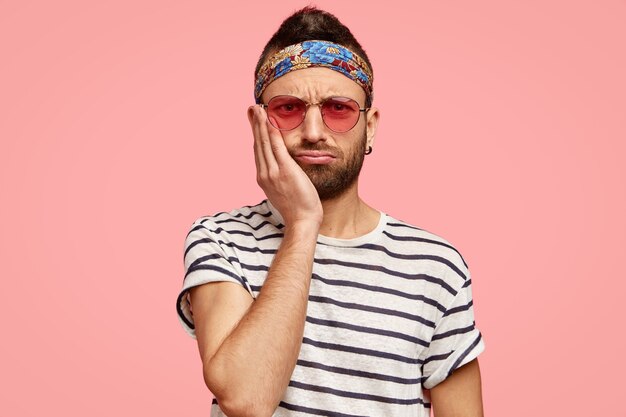 Uomo che indossa occhiali da sole rosa e bandana colorata