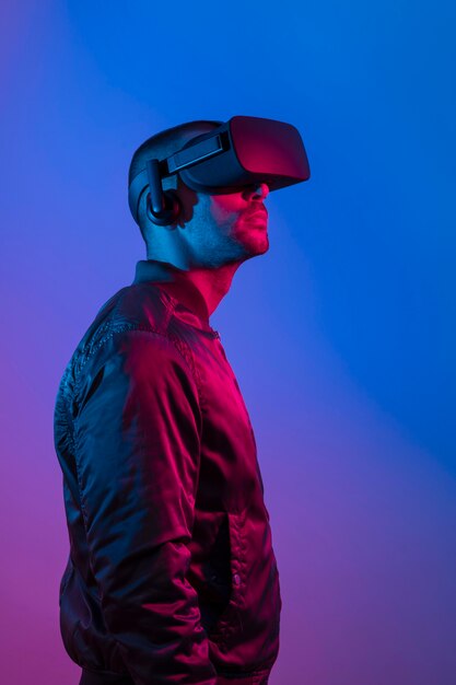 Uomo che indossa occhiali vr con luce blu e viola