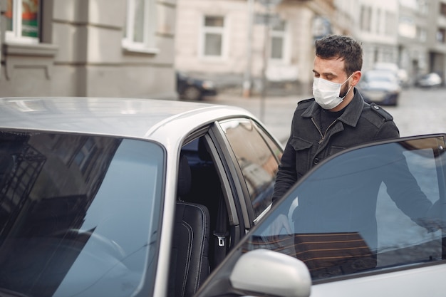 Uomo che indossa una maschera protettiva entrare in una macchina