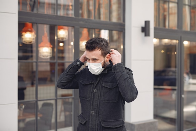 Uomo che indossa una maschera protettiva in strada