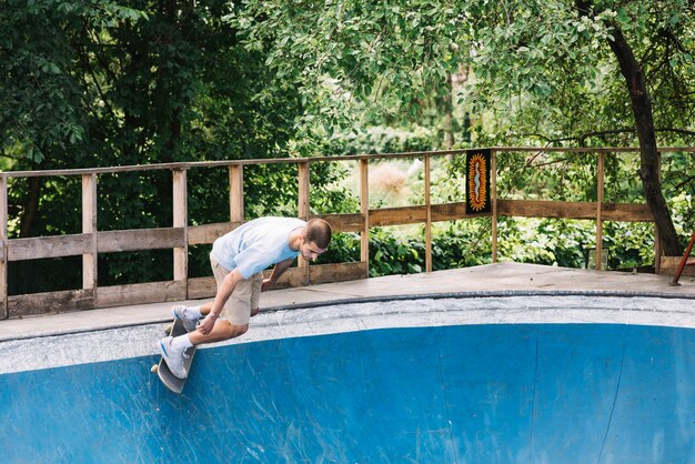 Uomo che inizia a cavallo sullo skateboard