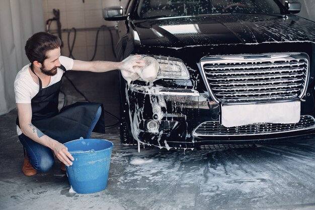 Uomo che lava la sua auto in un garage